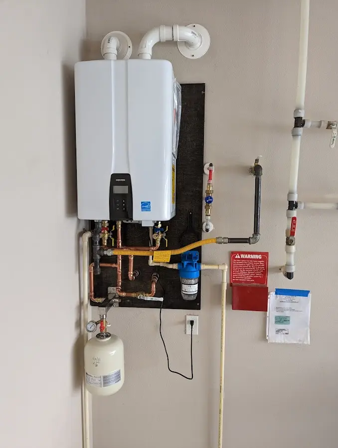 Professional plumber installing copper piping in a Park Layne home